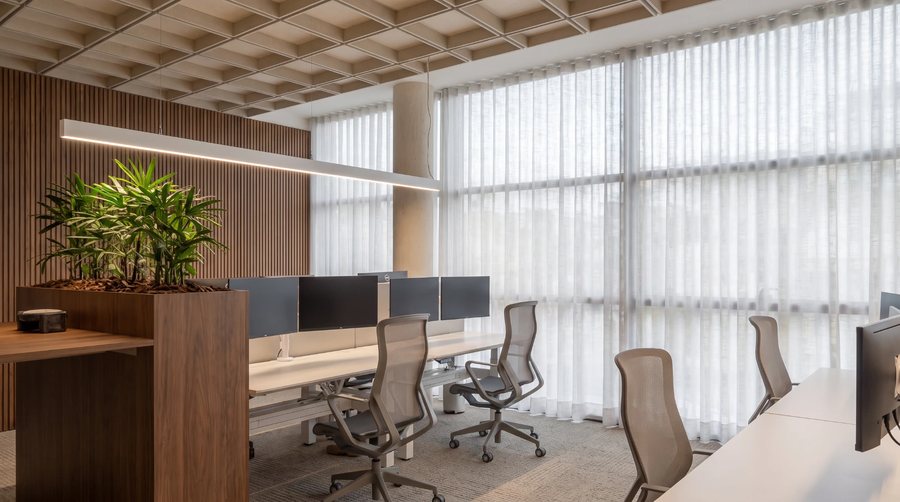 Oficina de la planta baja de Ona, con puestos de trabajo junto a los ventanales